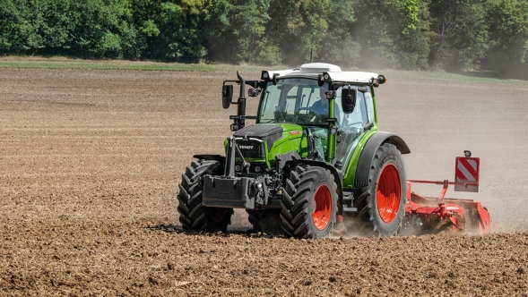 Fendt 200 Vario in azione Fendt 200 Vario in azione sul campo. Sullo sfondo si vedono vortici di polvere e alberi verdi.