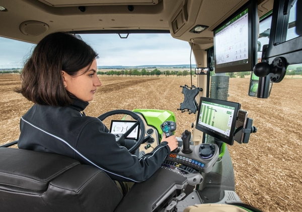 FendtONE con bracciolo multifunzionale Un agricoltore nella cabina di guida del trattore che utilizza FendtONE onboard