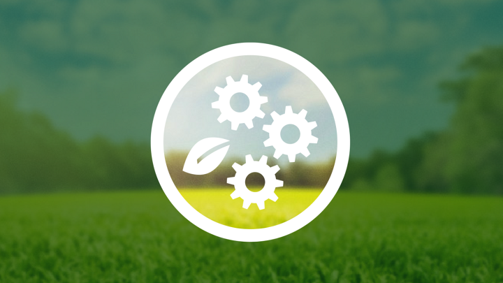 Due ingranaggi bianchi e un foglio bianco si trovano all’interno di un cerchio. Lo sfondo mostra un prato verde sotto il cielo blu, che al di fuori del cerchio è oscurato da uno strato verde scuro, in parte trasparente.