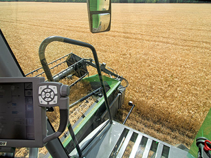 Vista della cabina di una mietitrebbia Fendt Serie L Vista interna della cabina di una mietitrebbia Fendt Serie L con una visuale diretta della barra di taglio, delle stoppie e dello spargitore di paglia durante il funzionamento in campo