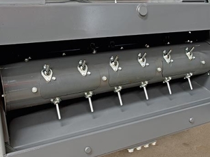 Primo piano del rullo di alimentazione di una mietitrebbia Fendt Serie L, che alimenta il raccolto in modo uniforme dalla barra falciante all'elevatore della granella.