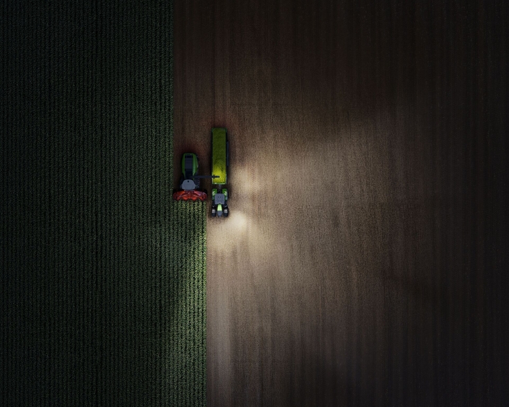 immagine scattata da un drone di un Fendt 800 Vario nella notte con luci accese - a sinistra.