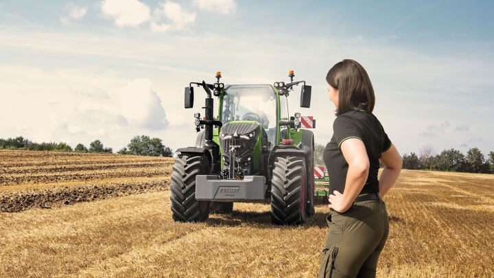 Un agricoltore si trova su un campo di stoppie davanti al suo Fendt 700 Vario Gen7.