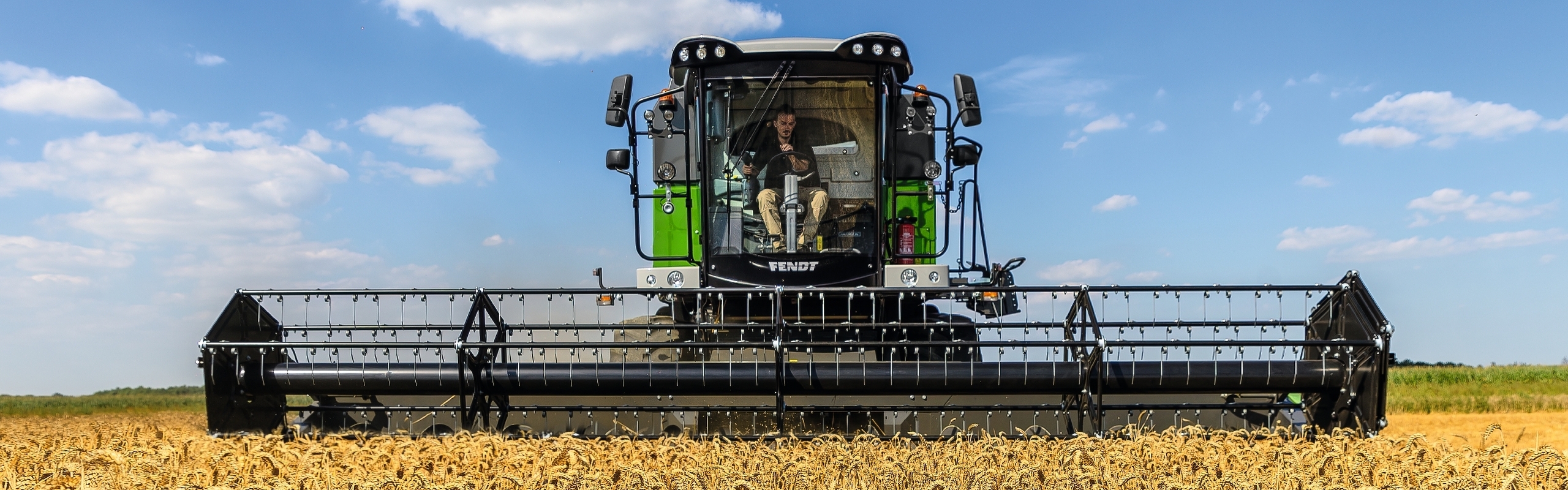 kviečių lauke „Fendt CORUS“ kombainu kuliantis ūkininkas