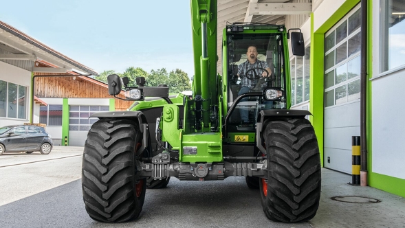 „Fendt Cargo T955“ vaizdas iš priekio Rangovo įmonėje „Fendt Cargo T955“ su ištiesta teleskopine svirtimi ir vairuotoju kabinoje vaizdas iš priekio.
