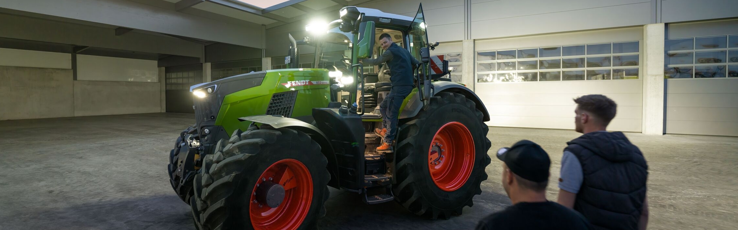 Vaizdas į rangovo įmonės vidinį kiemą, kuriame stovi vairuotojui paruoštas „Fendt 800 Vario“ traktorius su pilnu apšvietimu