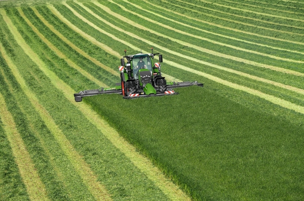 Fendt 600 Vario De groene Fendt 600 Vario-trekker maait met de groene aanbouwapparatuur Fendt Slicer op een groene weide. Op de achtergrond zijn maaisporen te zien.