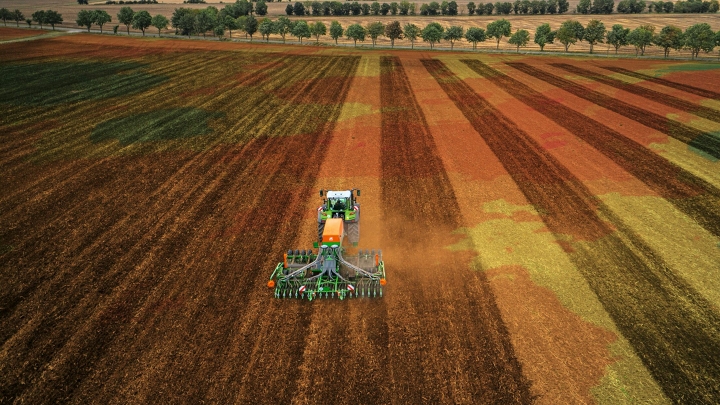 Een groene Fendt-tractor met werktuig bij het precies bewerken van de grond dankzij FendtONE-machineaansturing.