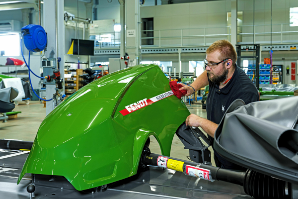 De fabriek van Fendt in Feucht Een Fendt-medewerker monteert iets op de kap van een Fendt Slicer.