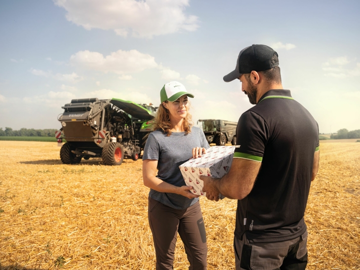 Een medewerker van AGCO Parts levert een reserveonderdeel op de boerderij aan een boerin