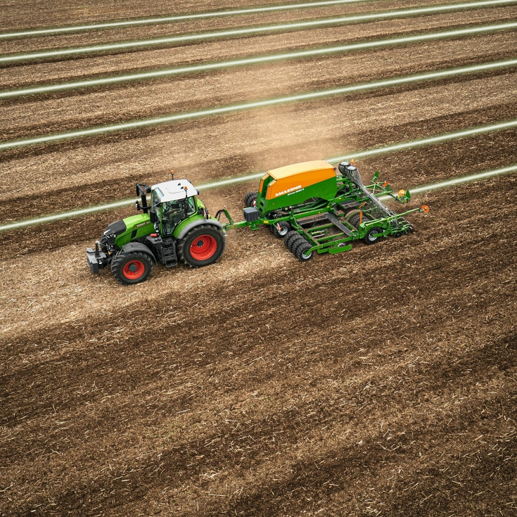 Een groene Fendt-tractor tijdens het bewerken van de grond met gebruikmaking van spoorgeleidingsoplossing Fendt Guide