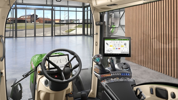 Binnenaanzicht van de VisioPlus cabine van een Fendt 300 Vario Gen5 met ergonomische bedieningsarmleuning, stuurwiel en terminal voor een moderne boerderij met glazen front