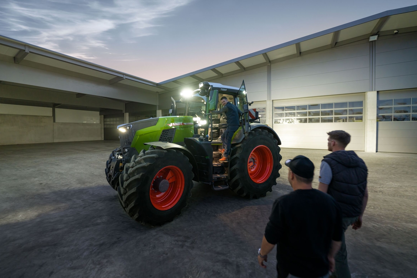 Zicht op de binnenplaats van een loonbedrijf dat voor de eigen rijders een Fendt 800 Vario klaar heeft staan, met alle verlichting aan