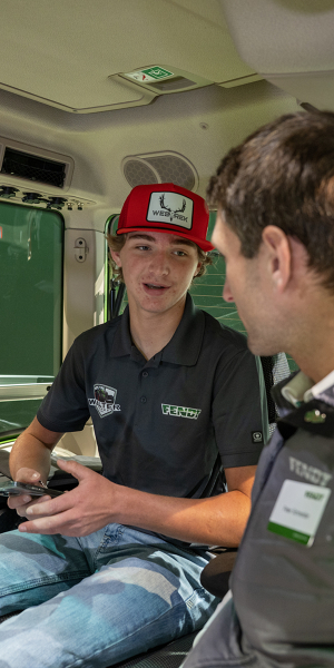 Advies en klantencontact op de Fendt-stand van de Agritechnica 2025 Een jonge boer laat zich door een Fendt-medewerker adviseren op een Fendt-tractor