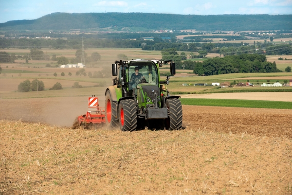 een groene Fendt 500 Vario op een stoppelveld tijdens het bewerken van de bodem