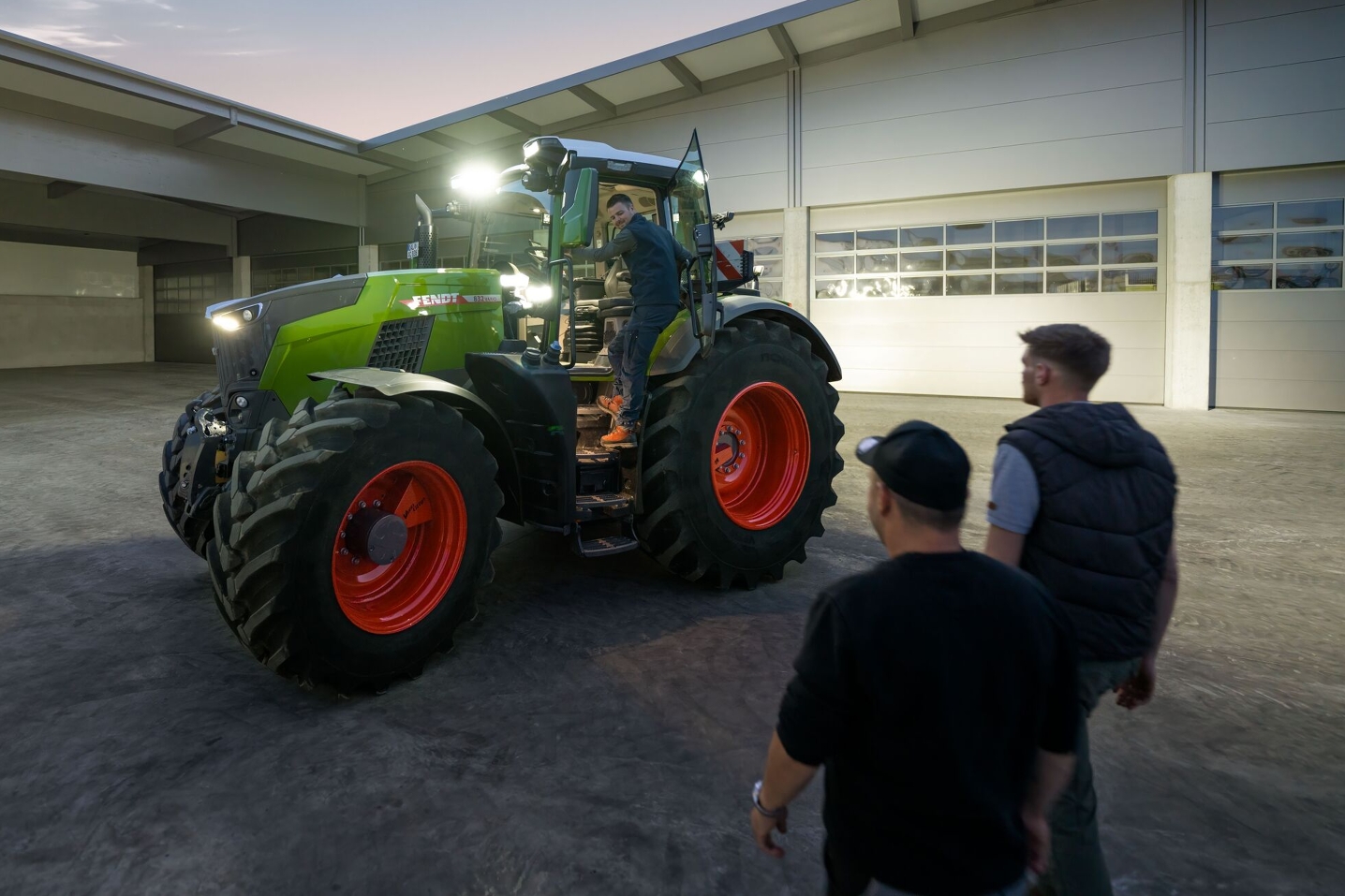 Blikk inn på gårdsplassen til en en maskinentreprenør med en Fendt 800 Vario traktor med full belysning klar for føreren