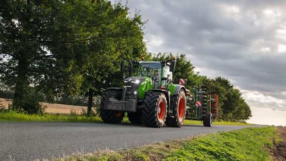 En Fendt 700 Vario Gen7 kjører på veien med et redskap.
