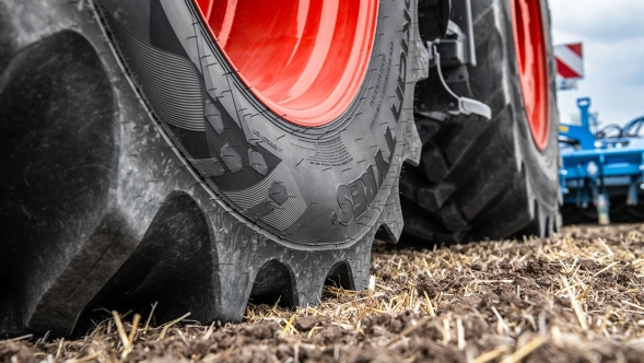 Zbliżenie na opony Fendt z czerwonymi obręczami kół na polu uprawnym