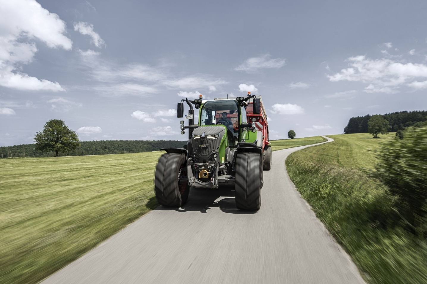 Fendt 700 Vario z przyczepą zbierającą jedzie latem po szosie