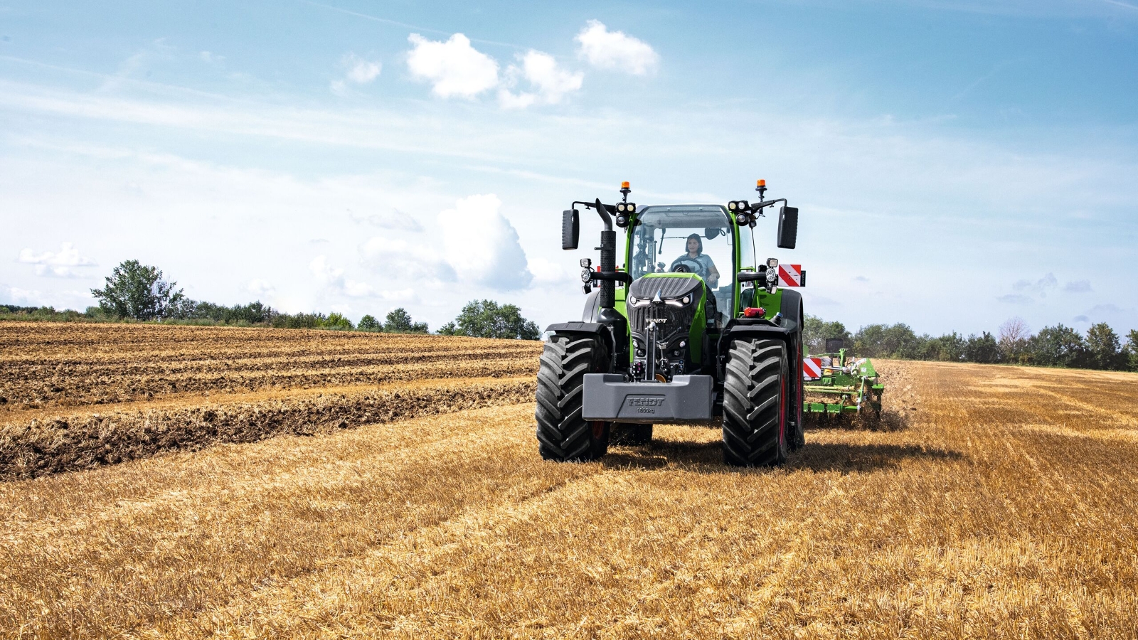 Fendt 700 Vario Gen7 Kobieta-rolnik jedzie ciągnikiem Fendt 700 Vario Gen7 po polu.