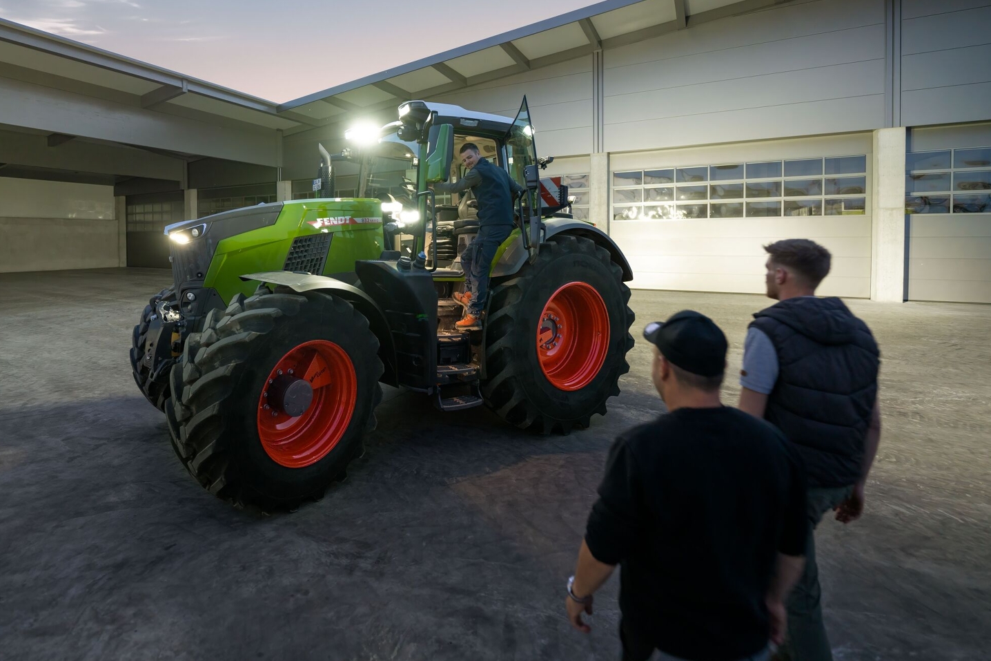 Utsikt över gårdsplanen hos en entreprenör som har Fendt 800 Vario-traktorn med full belysning redo för sina förare