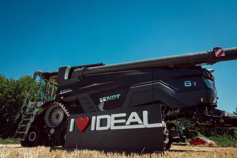 На фотографії зображено Fendt IDEAL на зерновому полі. На передньому плані — великий плакат «i love IDEAL».