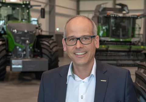 Фотографія Крістіана Еркенса, директора з продажу Fendt EME (Європа та Близький Схід) з трактором Fendt на задньому плані