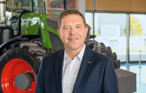 На фотографії зображений Крістоф Гроблінгхофф, віце-президент і голова правління компанії Fendt. На задньому плані видно трактор Fendt.