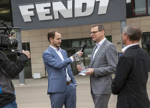 Телевізійна команда з мікрофонами та камерами бере інтерв'ю у Вальтера Вагнера перед Fendt Forum.