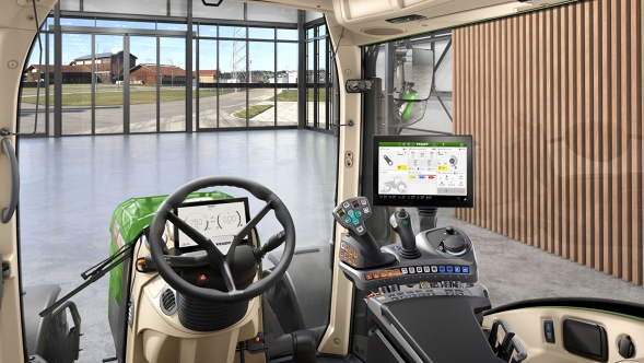 Внутрішній вигляд кабіни VisioPlus у Fendt 300 Vario Gen5 з ергономічним важелем керування, кермовим колесом та великим терміналом на фоні сучасного подвір'я ферми зі скляним фронтоном