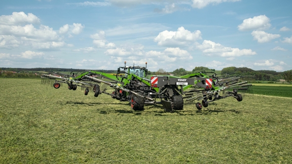 View of a green field on which the Fendt Former 14055 PRO is performing a test run for raking