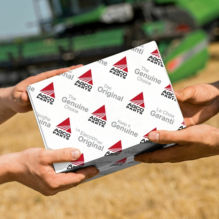 Handover of an AGCO Parts package in the field.