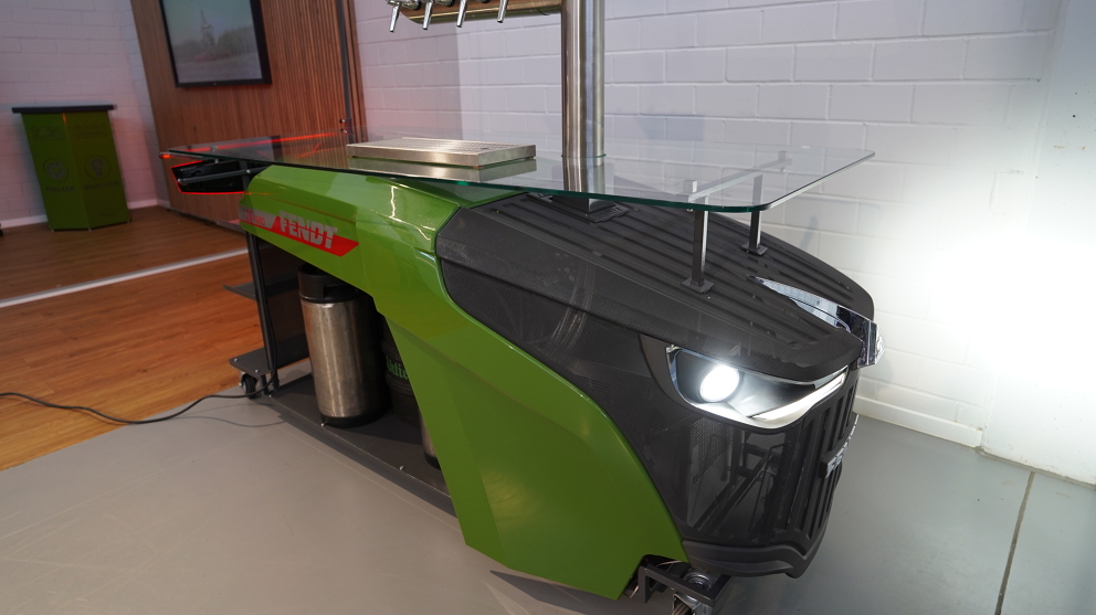 Fendt dispensing station (diagonally from the front) with Fendt logo, a glass shelf and front and rear lights switched on.