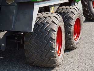 Two large tires with red rims mounted on an agricultural machine.