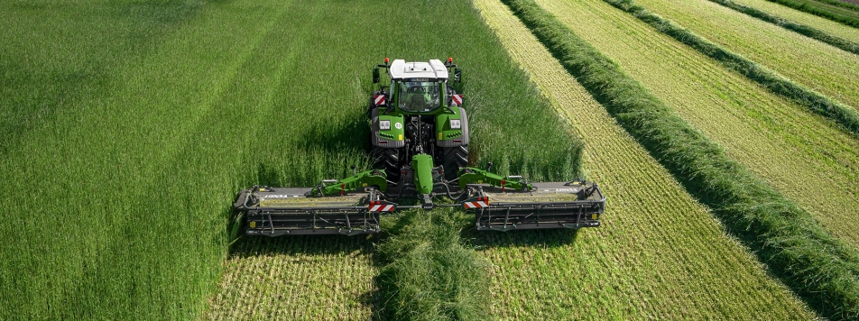 Fendt Slicer 960 KCB Pro A Fendt tractor with Fendt Slicer 960 KCB Pro mower combination on a meadow while mowing from a bird's eye view.