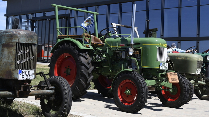 Several Fendt vintage tractors are lined up in front of the Fendt Forum.