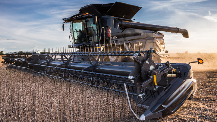 A Fendt IDEAL combine harvesting in the sunset