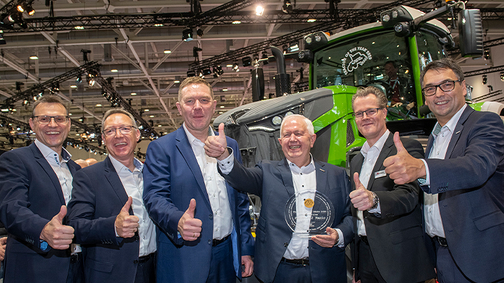 Fendt executives stand side by side holding "Tractor of the Year 2020" award in hand
