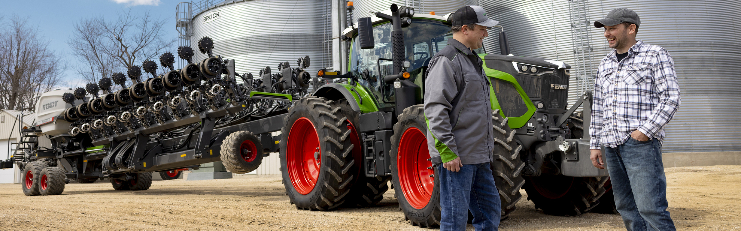 Fendt technician visits farmer on his farm with Fendt tractor and Momentum Planter in the background