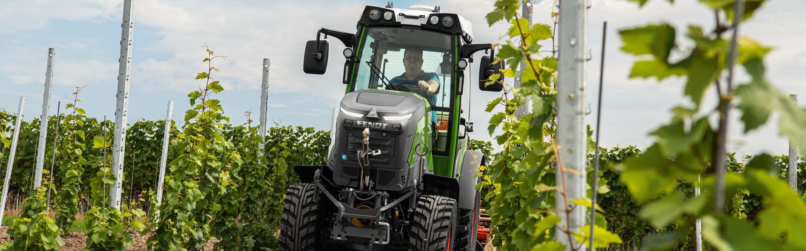 Fendt e100 V being driven in a vineyard Fendt e100 V being driven in a vineyard