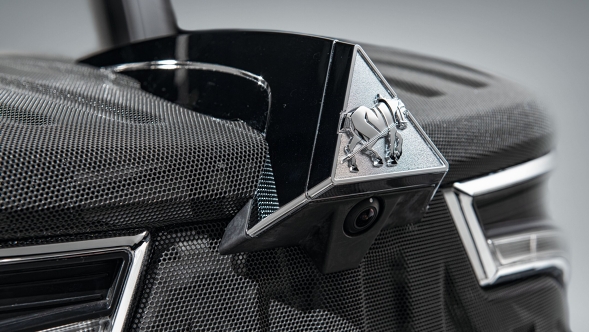 Close-up of the bonnet of the Fendt 900 Vario with integrated bonnet camera in the Dieselross emblem, in shades of grey, anthracite and black.