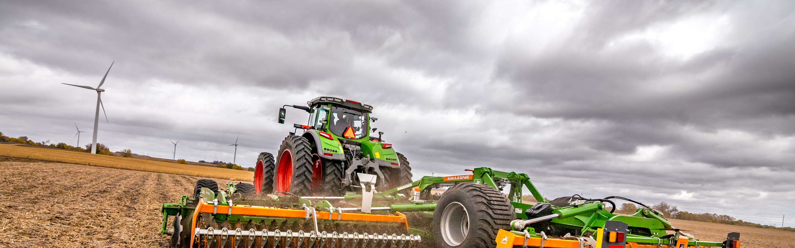 Fendt 1000 Vario Tractor puling tillage in Fendt 1000 Vario Tractor puling tillage in a field on a cloudy day