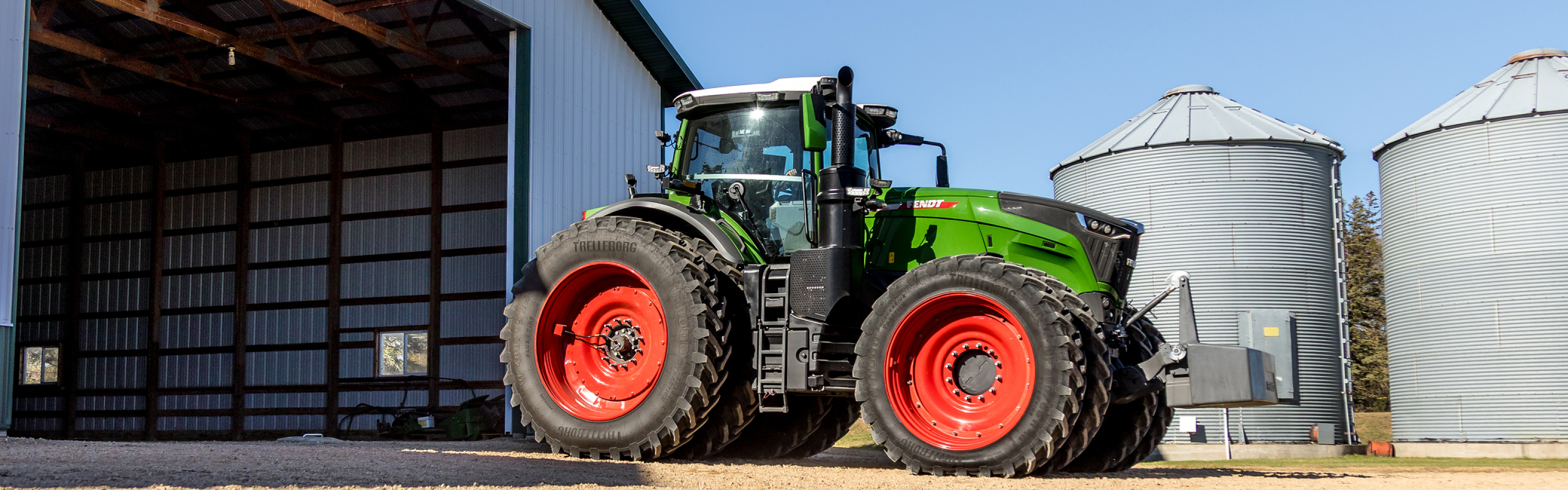 Farmer driving Fendt 1000 Vario out of the barn Farmer driving Fendt 1000 Vario out of the barn