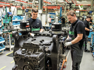 Two employees work concentratedly at a production workstation in the Fendt factory in Marktoberdorf.