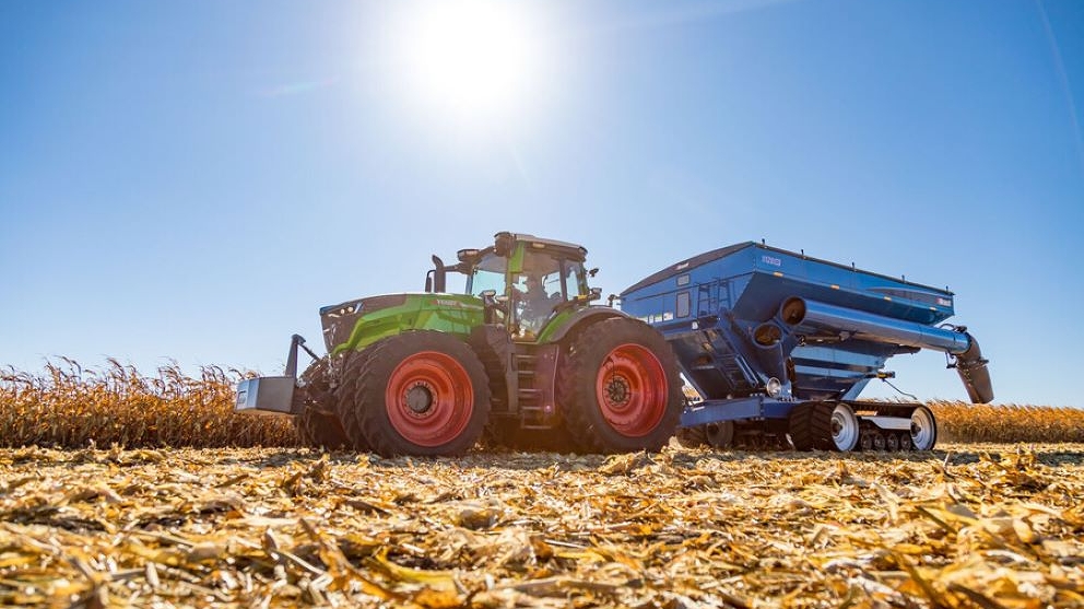 Fendt 1000 Vario Tractor pulling a grain cart in corn field