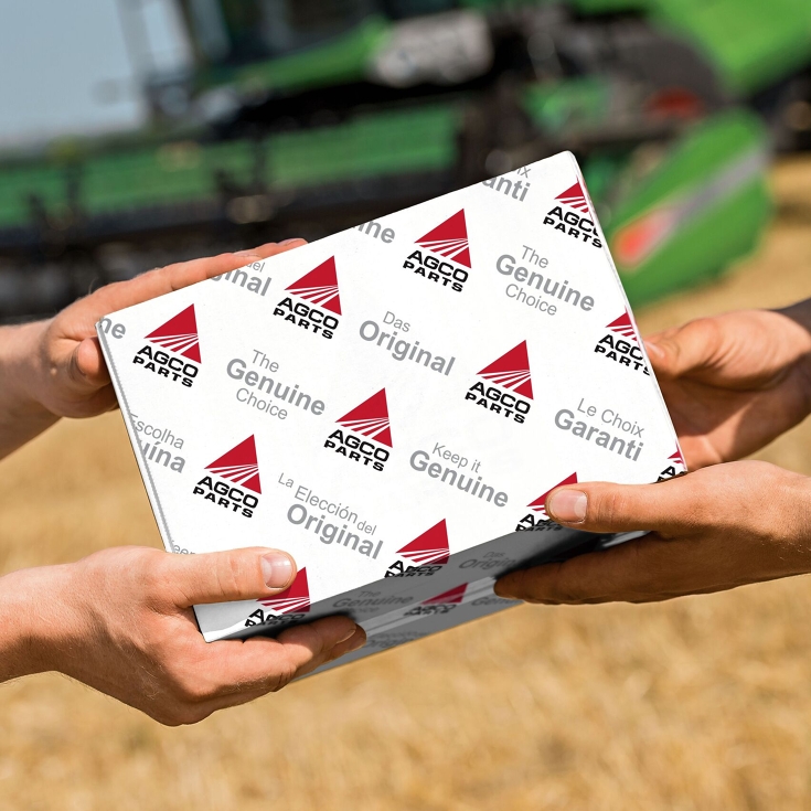 Handover of an AGCO Parts package in the field.