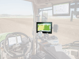 Interior view of a tractor cab with multiple screens and controls.